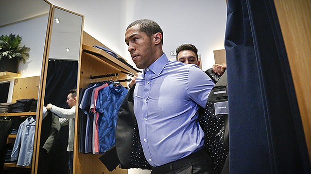 While shopping at Bonobos on Monday, customer J.P. Grant gets assistance from guide Reynaldo Sanchez, as Grant shops for clothing at the brand's Guideshop, in New York's Financial District. More shoppers are looking to social media or curated selections for fashion inspiration. That adds to the woes of mall-based stores, as people are already buying fewer clothes, spending online or at discounters when they do, and demanding more personal and convenient ways to buy.