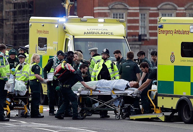 Emergency services transport an injured person to an ambulance close to the Houses of Parliament on Wednesday in London after an apparent terror attack that left five dead and 40 others injured.