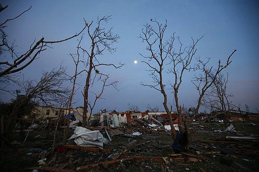 In this Feb. 8, 2017 file photo, the moon rises over a destroyed neighborhood in the aftermath of a tornado that tore through the New Orleans East section of New Orleans. Forecasters are warning of severe storms as a powerful system moves across the central United States, the start of what could a turbulent stretch of spring weather over the next few days. The bull's-eye for some of the most fearsome weather _ including possible tornadoes, s over parts of Louisiana, Arkansas and east Texas on Friday, March 24 forecasters said.