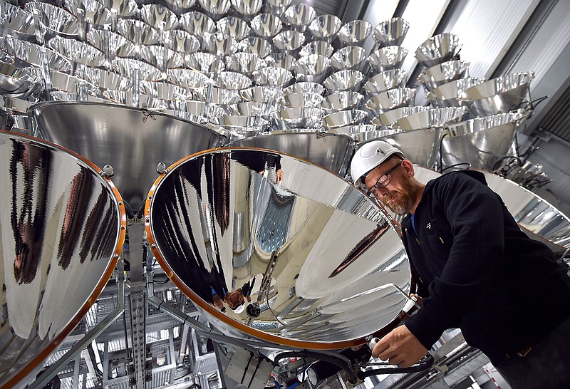 In this March 21, 2017 photo engineer Volkmar Dohmen stands in front of xenon short-arc lamps in the DLR German national aeronautics and space research center in Juelich, western Germany. The lights are part of an artificial sun that will be used for research purposes. 