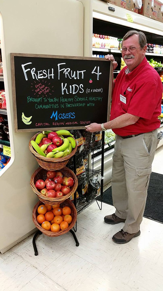 Jim Mooney, store manager at Moser's in Holts Summit, stands near new fruit baskets to be featured inside store.