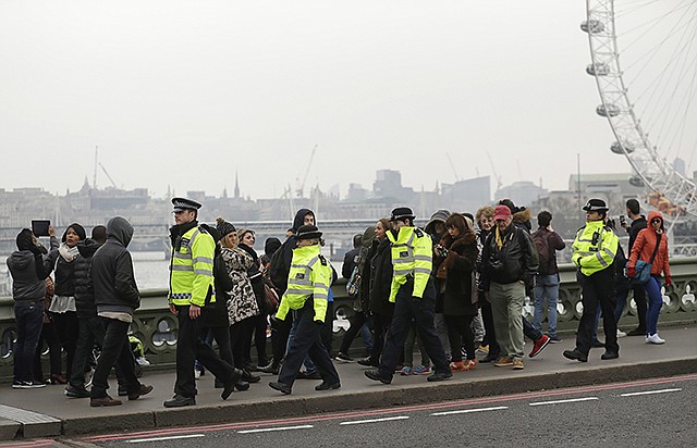 Police officers patrol Friday on Westminster Bridge in London. On Thursday, authorities identified a 52-year-old Briton as the man who mowed down pedestrians and stabbed a policeman to death outside Parliament in London, saying he had a long criminal record and once was investigated for extremism — but was not currently on a terrorism watch list.