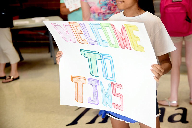 A student holds a welcome sign at Thomas Jefferson Middle School's open house before its first day of classes on Wednesday, Aug. 17, 2016. 