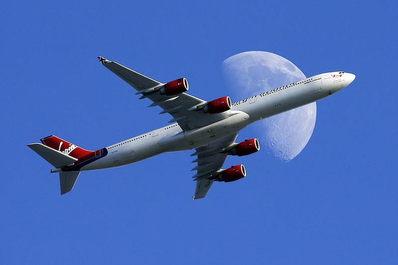 In this Sunday, Aug. 23, 2015, file photo, a Virgin Atlantic passenger plane crosses a waxing gibbous moon on its way to the Los Angeles International Airport, in Whittier, Calif. Alaska said Wednesday, March 22, 2017, that it will retire the Virgin brand, probably in 2019. Alaska announced in 2016, that it was buying Virgin, but CEO Brad Tilden held out hope to Virgin fans that he might keep the Virgin America brand, and run it and Alaska as separate airlines under the same corporate umbrella. 