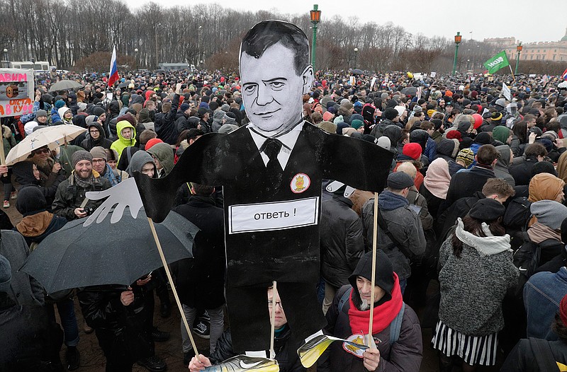 Protesters hold a cardboard cutout poster depicting Russian Prime Minister Dmitry Medvedev at Marsivo Field in St.Petersburg, Russia, Sunday, March 26, 2017. Thousands of people crowded in St.Petersburg on Sunday for an unsanctioned protest against the Russian government, the biggest gathering in a wave of nationwide protests that were the most extensive show of defiance in years. 