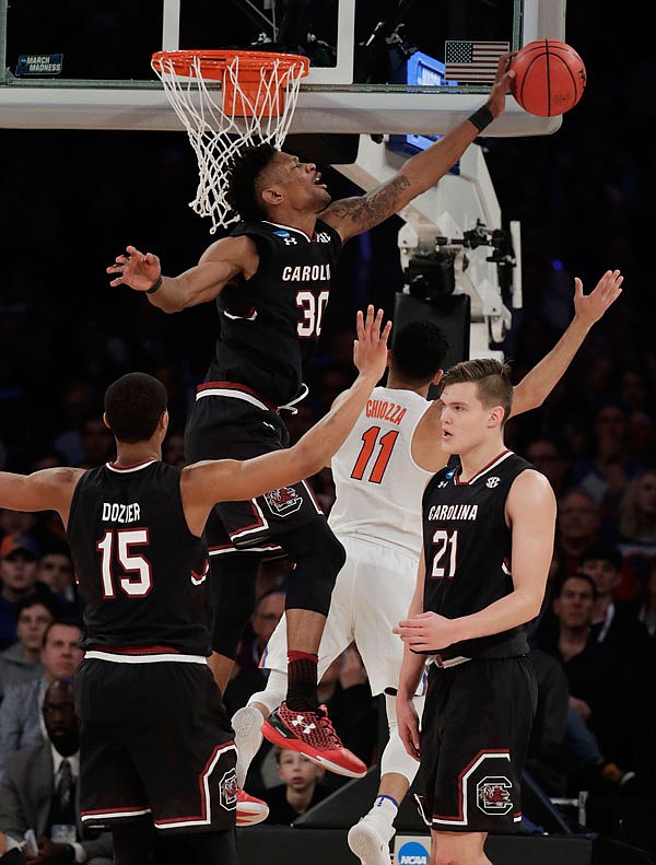South Carolina forward Chris Silva (30) blocks a shot by Florida guard Chris Chiozza (11) during the second half of Sunday's East Regional championship in the NCAA Tournament in New York.