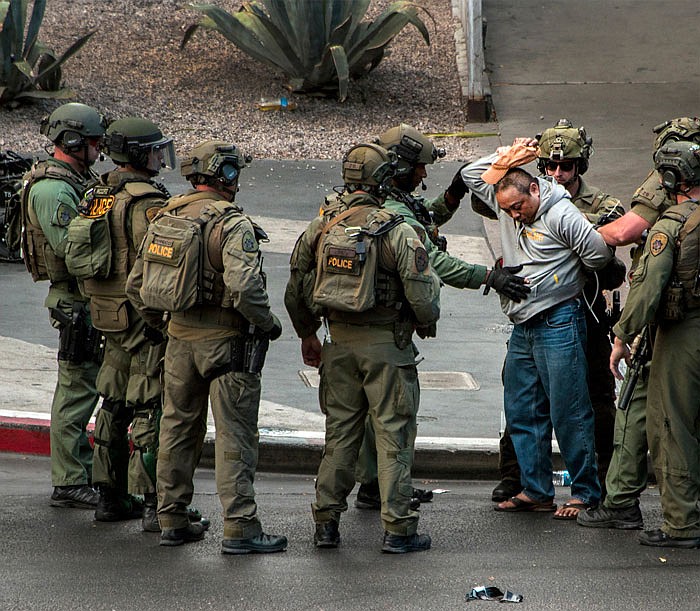 A suspect surrenders to SWAT officers after being barricaded for many hours on a bus after a fatal shooting in the vehicle earlier Sunday which down the busy tourism corridor near the Cosmopolitan hotel-casino in Las Vegas on Saturday.
