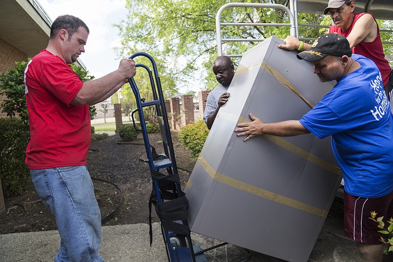 Volunteers and residents of Randy Sams' Outreach Shelter move a filing cabinet into the shelter's new office on Monday. The building will host the shelter's administrative offices,  Be the Blessing Bakery and other resources for clients.n BOTTOM LEFT: The new Randy Sams' Outreach Shelter office. 