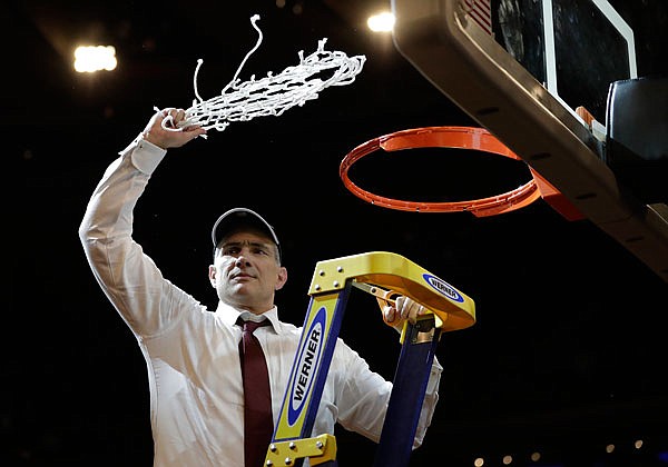 South Carolina head coach Frank Martin swings the net around after cutting it down Sunday after beating Florida 77-70 in the East Regional final of the NCAA Tournament in New York. 