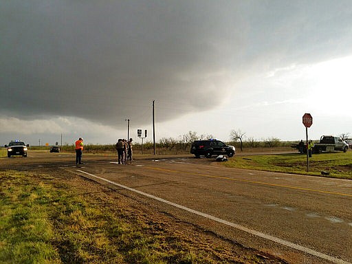 Texas Department of Public Safety troopers investigate a two-vehicle crash that left several storm chasers dead Tuesday, March 28, 2017, near Spur, Texas. The storms spawned multiple funnel clouds and an occasional tornado in open areas of West Texas on Tuesday afternoon. The crash happened at a remote intersection near the town of Spur, about 55 miles southeast of Lubbock. (Ellysa Gonzalez/Lubbock Avalanche-Journal via AP)