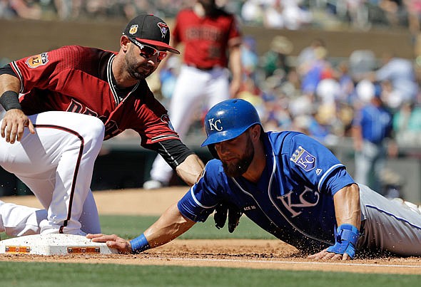 Alex Gordon of the Royals dives safely back to first as Diamondbacks first baseman Daniel Descalso applies the tag in a spring training game last week in Scottsdale, Ariz.