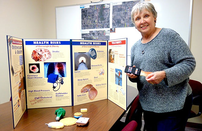 Pam Phelps, director of the Callaway County Health Department's Medical Reserve Corps and organizer of the Rush Hour Passport program, displays some of the visual aids to be used during the upcoming class on obesity and being overweight.