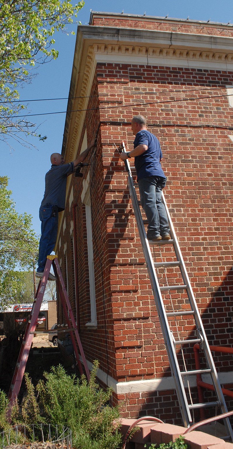 Workers of Steelcrest Security, in Texarkana, are drilling into the walls of the Atlanta Pubic Library to install outside security cameras. A total of 22 cameras now protect the inside and outside of the building for better management and safety of the public facility. The $4,500 expenditure was raised by Friends of the Library.