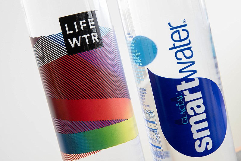 In this Thursday, March 16, 2017, photo, bottles of Lifewtr and Smartwater are displayed in Philadelphia. As bottled water surges in popularity, Coke, Pepsi and other companies are using celebrity endorsements, stylish packaging and fancy filtration processes like "reverse osmosis" to sell people on expanding variations of what comes out of the tap. They're also adding flourishes like bubbles, flavors or sweeteners that can blur the lines between what is water and what is soda. 