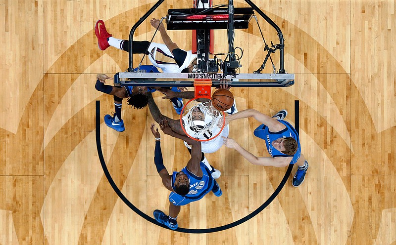 New Orleans Pelicans forward DeMarcus Cousins, center watches a shot roll on the rim surrounded by Dallas Mavericks forward Harrison Barnes (40), forward Dirk Nowitzki, right, and forward Nerlens Noel, left, in the first half of an NBA basketball game in New Orleans, Wednesday, March 29, 2017. 