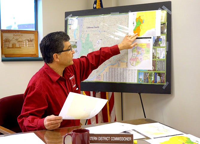 In this March 31, 2017 photo, Callaway County Commissioner Roger Fischer points to the western district of the county, highlighted in orange and green. The townships affected by his proposed health ordinance are outlined in black in the lower map.