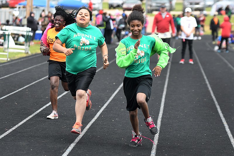 Nashville student Titianyia Maxwell, from left, and Mineral Springs Elementary students Jenny Domingues and Adriyanna Wooten compete in the 50-meter run Wednesday during the Special Olympics of Arkansas Area 11 Spring Games at Genoa High School. 