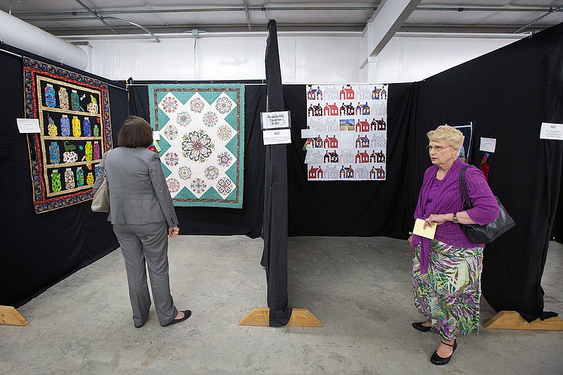 Texarkana, Texas, Ward 3 council member Betty Williams, right,  and Texarkana, Ark., Mayor Ruth Penney-Bell choose the quilts Thursday they will be awarding at the 26th annual Miller-Bowie Quilt Board Show at the Four States Fairgrounds. The show opens to the public today and runs through Saturday. Over 75 quilts are on display. 