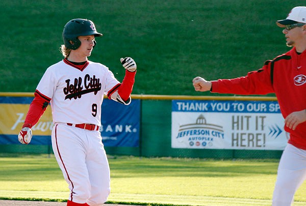 Kade Franks of the Jays bumps fists with first base coach J.R. Simmons during Thursday's game against Fatima at the Capital City Invitational at Vivion Field.