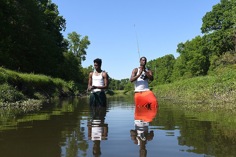 Bobby Forte, left, and Kevin Robertson enjoy an afternoon of fishing Friday at Swampoodle Creek. "We see as many turtles and snakes as we do fish," said Robertson. 