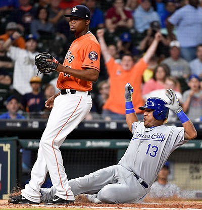 Royals catcher Salvador Perez slides home to score a run on a passed ball as Astros relief pitcher Jandel Gustave stands near the plate during the eighth inning of Friday night's game in Houston.