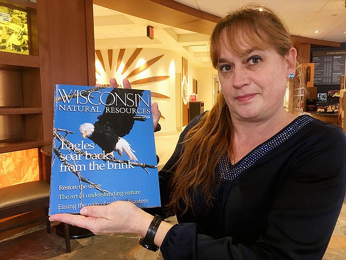 Former Wisconsin Natural Resources Magazine editor Natasha Kassulke holds a copy of the publication at the University of Wisconsin-Madison's Memorial Union in Madison, Wis. Kassulke said she quit her job with the magazine after Gov. Scott Walker's administration demanded to vet every article ahead of publication. Walker's state budget now calls for eliminating the magazine, outraging the publication's 80,000-plus subscribers.