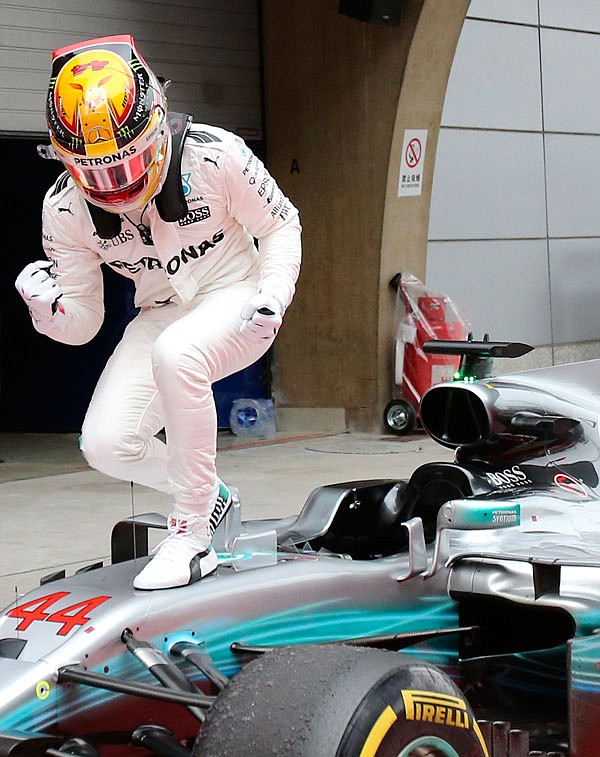 Mercedes driver Lewis Hamilton of Britain strikes a pose on his car Sunday after winning the Chinese Formula One Grand Prix at the Shanghai International Circuit in Shanghai, China.