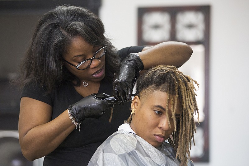 Nina Nicole demonstrates loc maintenance on Ashley Robinson's hair Monday at Charlotte's Hair Co. and Boutique. Nicole is a natural hair specialist and has a line of products for natural hair. This is the first class offered at the boutique and more will be offered in the future.