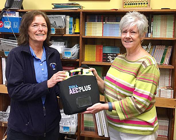Callaway County EMS Training Officer Kelly Drennan presents a Zoll AED Plus to St. Peter School Principal Teri Arms. St. Peter Catholic Parish recently partnered with Callaway County EMS to establish a public access defibrillation program.