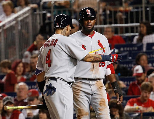 Dexter Fowler (25) is congratulated by Cardinals teammate Yadier Molina after scoring on Stephen Piscotty's single during the third inning of Monday night's game against the Nationals in Washington.