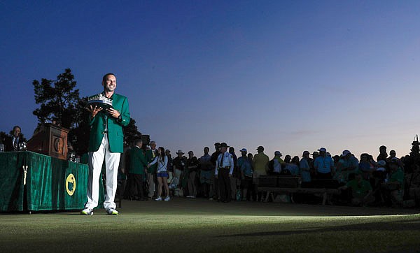Wearing the green jacket, Sergio Garcia holds the trophy during a ceremony Sunday night after winning the Masters in Augusta, Ga.