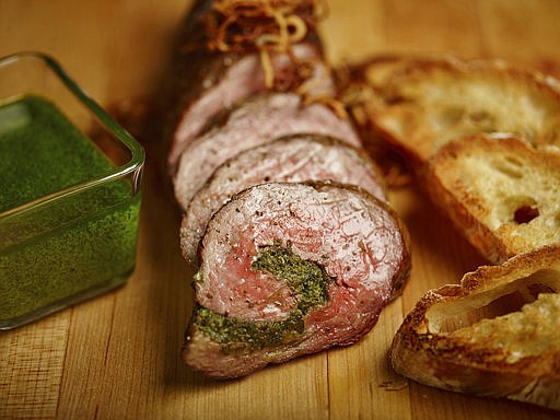 This March 29, 2017 photo provided by The Culinary Institute of America shows a Chimichurri-stuffed flank steak in Hyde Park, N.Y. This dish is from a recipe by the CIA. (Phil Mansfield/The Culinary Institute of America via AP)