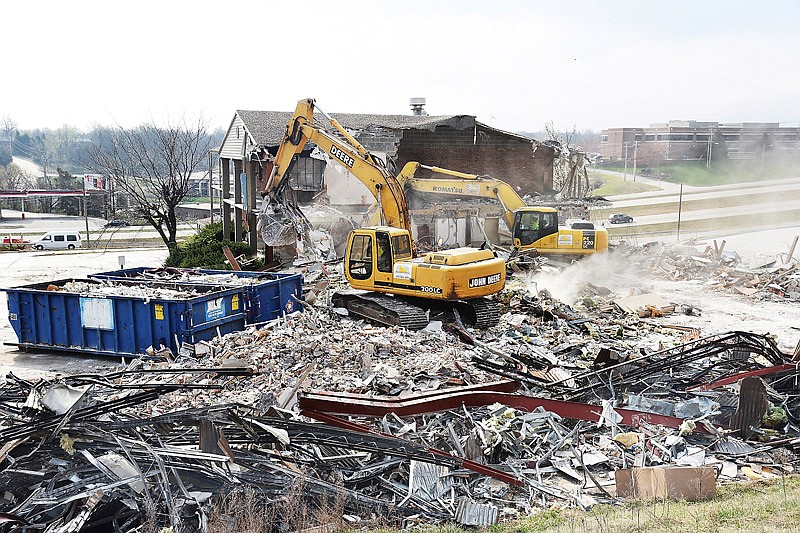 In this March 21, 2017 photo, demolition of the Truman Hotel begins with the southern most building on the property. Darin Holtmeyer, an operator from Don Schnieders Excavating, uses a track hoe with a bucket to pull down the building while Wes Libbert, foreground left, uses a track hoe with a thumb excavator to separate recyclables and sort them. Developer Puri Group of Enterprises (PGE) plans to build hotels and a restaurant on the Jefferson City property.