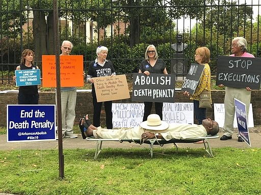 This photo provided by Sherry Simon shows Pulaski County Circuit Judge Wendell Griffen taking part of an anti-death penalty demonstration outside the Governor's Mansion Friday, April 14, 2017 in Little Rock, Ark. Griffen issued a temporary restraining order Friday blocking the state from using its supply of vecuronium bromide after a company said it had sold the drug to the state for medical purposes, not capital punishment. Local media outlets had tweeted photos and video of Griffen appearing to mimic an inmate strapped to a gurney at the demonstration. Attorney General Leslie Rutledge's office said she planned to file an emergency request with the state Supreme Court to vacate Griffen's order, saying Griffen shouldn't handle the case. 