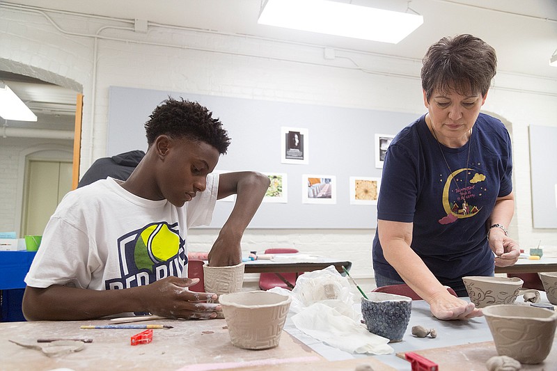 Gabriel West makes a cup and bowl Saturday at the Texarkana Regional Arts and Humanities Center. West became interested in pottery after seeing what his mother made at a pottery class taught by the same teacher, Chris Thomas.