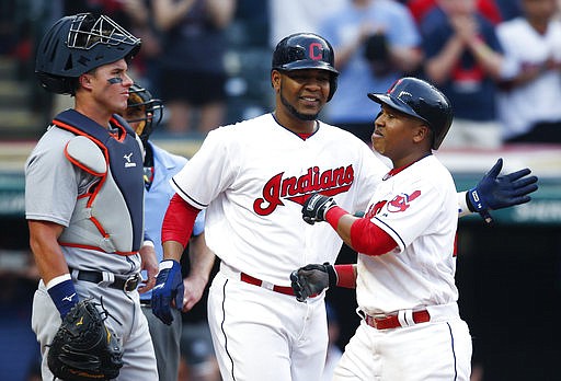 Cleveland Indians' Jose Ramirez, right, gets congratulations from Edwin Encarnacion, center, after hitting a three run home run off Detroit Tigers starting pitcher Anibal Sanchez as catcher James McCann looks on during the eighth inning of a baseball game, Saturday, April 15, 2017, in Cleveland. 