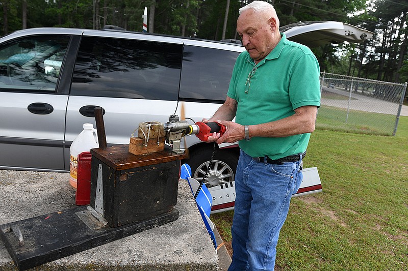 John Gunn uses a hand starter to test a propellor engine for a control-line airplane Tuesday at Spring Lake Park in Texarkana, Texas. Gunn has been flying control-line planes as a hobby since he was 15. "It's like ice skating in the sky," he said. 
