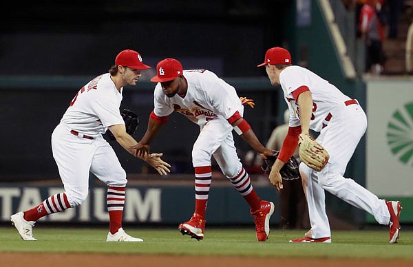 (From left) Cardinals outfielders Randal Grichuk, Dexter Fowler and Stephen Piscotty celebrate following Tuesday night's  2-1 victory against the Pirates at Busch Stadium.