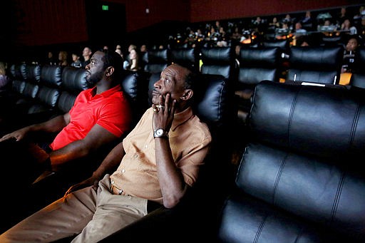 In a Friday, March 31, 2017 photo, exonerees Johnnie Lindsey, right, and Christopher Scott watch a screening of "True Conviction", a documentary film by Jamie Meltzer that features the men, at Alamo Drafthouse in Dallas.  "True Conviction," tells the story of three Dallas County exonerees who now search for others still locked up in Texas prisons for crimes they did not commit. 