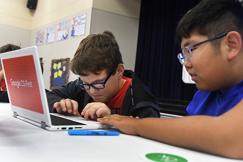 Isaak Helms, left, and Daniel Song work on a coding project together Wednesday during the Google CS First Roadshow at Martha and Josh Morriss Math and Engineering Elementary School. The CS First Roadshow is a computer science education program developed by Google that teaches children the importance of STEM education learning with an interactive coding experience. 
