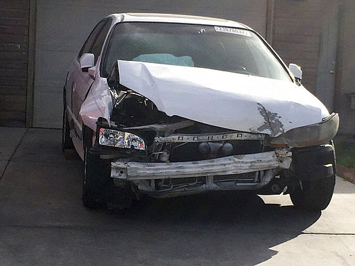 In this Tuesday, April 18, 2017, photo, a 2002 Honda Accord involved in a March 3, 2017, crash in which an exploding Takata air bag inflator badly injured the driver, Karina Dorado, sits in a driveway in Las Vegas. The incident has exposed a danger posed by the recalled parts. Nothing prevents the reuse of air bags from older models to fix wrecked cars that can then be resold, often to unsuspecting buyers.