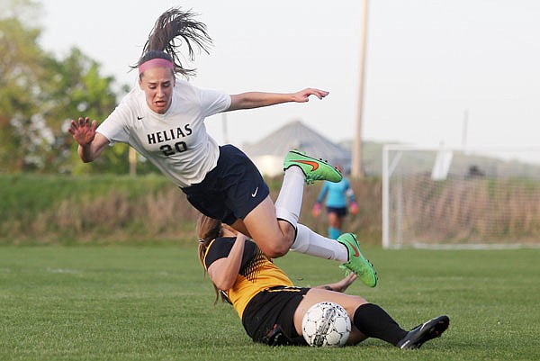 Jennifer Szumigala of Helias goes airborne after a collision with a Sedalia Smith-Cotton player during Wednesday's game at the 179 Soccer Park.