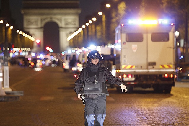 A police officer stands guard Thursday after a fatal shooting in which a police officer was killed along with an attacker on the Champs Elysees in Paris, France. French media are reporting three police officers were shot, one fatality, Thursday on the famed shopping boulevard.