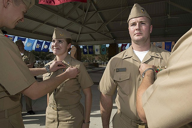 Lt j.g. Marquette Leveque, left, and Lt. j.g. Kyle McFadden, both of the USS Wyoming, receive their pins in Decemeber 2012 to indicate they're qualified to serve on submarines in a ceremony at Naval Submarine Base Kings Bay in Georgia. With women now serving on submarines, future subs are being built to specifically accommodate gender differences including height, reach and strength. The first vessel built with some of the new features is expected to be delivered in 2021.