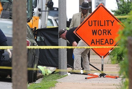 Police investigate a triple shooting in which two Laclede Gas workers were shot and killed in St. Louis on Thursday, April 20, 2017. Police say the shooter also shot and killed himself. (JB Forbes/St. Louis Post-Dispatch via AP)