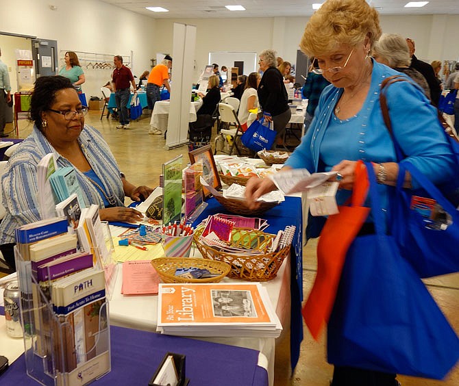 Sherry McBride, adult services reference librarian, shares information about the Callaway County Public Library with Betty Jennings, of Fulton, on Thursday at the SERVE Senior Expo.