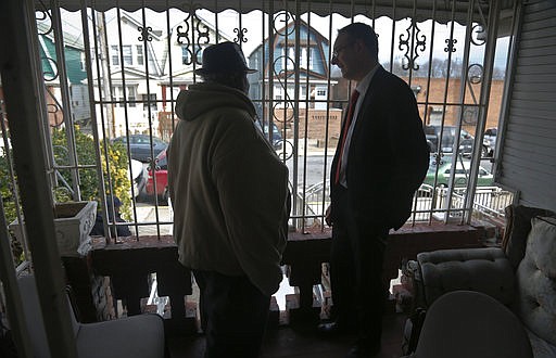 In this Feb. 1, 2017, photo, Raymond Murray gets a visit from his lawyer, Robert Seewald, right, at his home in New York. Murray is the victim of deed theft, a foreclosure fraud where older people are mostly the target.