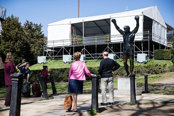 Tourists visit the Rocky statue Tuesday as construction continues for the NFL draft on the steps of the Philadelphia Museum of Art in Philadelphia.