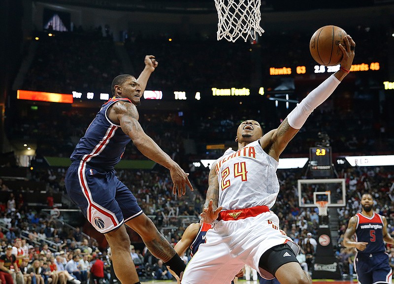 Atlanta Hawks forward Kent Bazemore (24) is fouled by Washington Wizards guard Bradley Beal (3) as he goes to the basket during the first half of an NBA playoff basketball game Saturday, April 22, 2017, in Atlanta. 