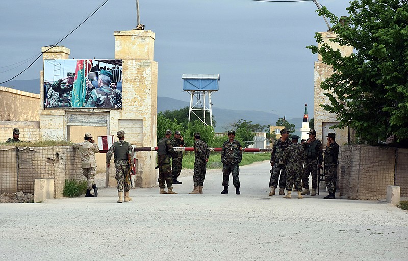 Afghan soldiers stand guard at the gate of a military compound after an attack by gunmen in Mazar-e- Sharif province north of kabul, Afghanistan, Friday, April 21, 2017. Gunmen wearing army uniforms stormed a military compound in the Balkh province, killing at least eight soldiers and wounding 11 others, an Afghan government official said Friday. 